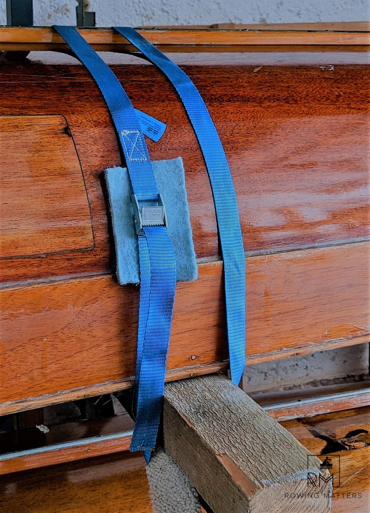 Das Boot ist mit einem Gurt mit Klemmschloss gesichert. Zum Schutz liegt ein Stück Teppich unter dem Schloss.